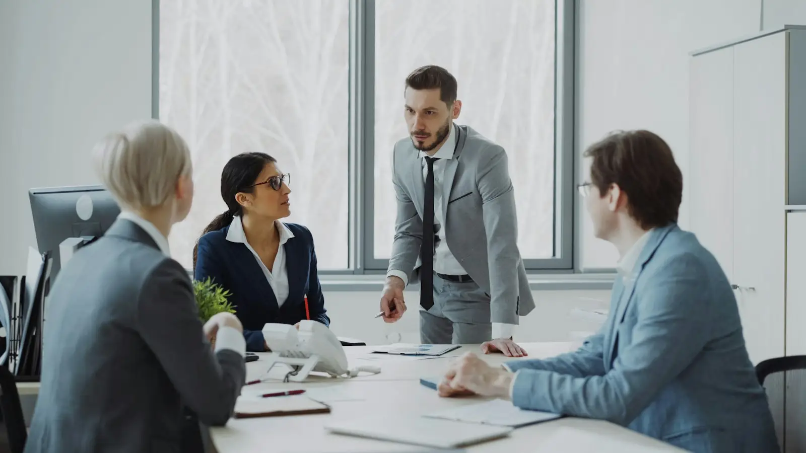 Four colleagues in a meeting around an office table