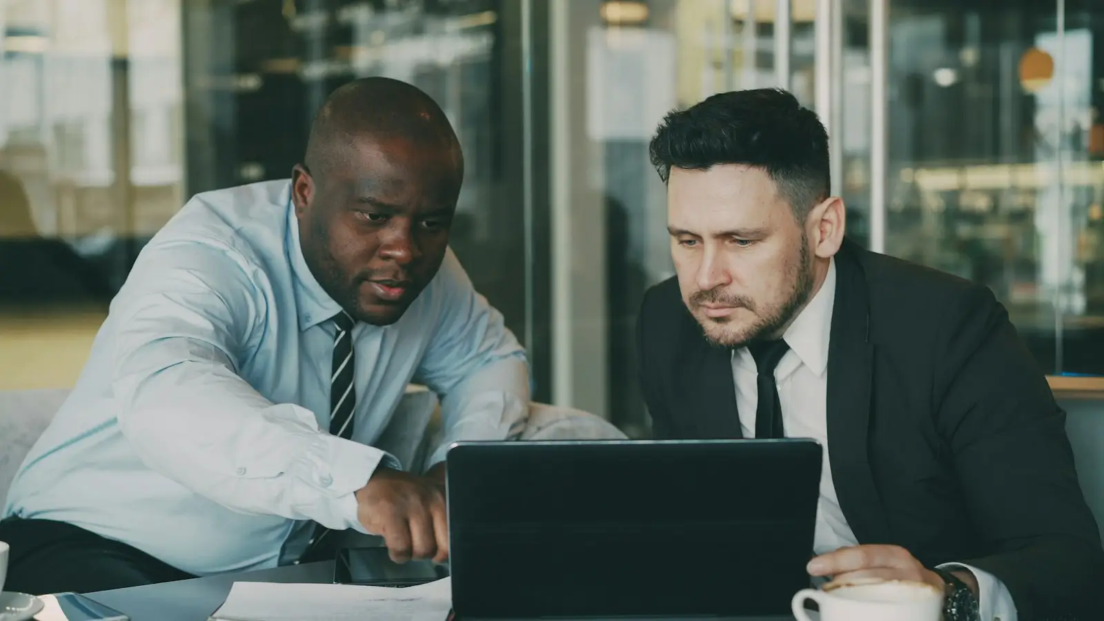 Two colleagues reviewing something together on a laptop